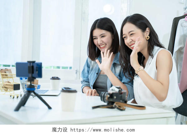 有魅力的亚洲女人通过智能手机在线销售产品